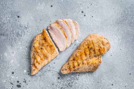 BBQ grilled and sliced chicken breast fillet steak. Gray background. Top view