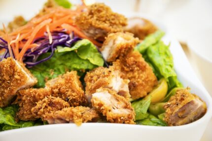 Closeup of fried chicken vegetables salad