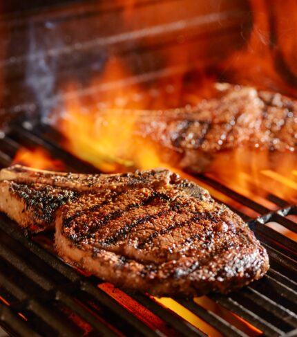 ribeye steaks on the grill over the open flame